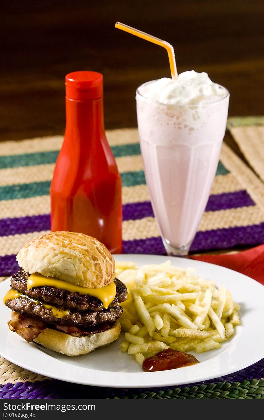 Cheeseburger with fries and strawberry milkshake. Cheeseburger with fries and strawberry milkshake