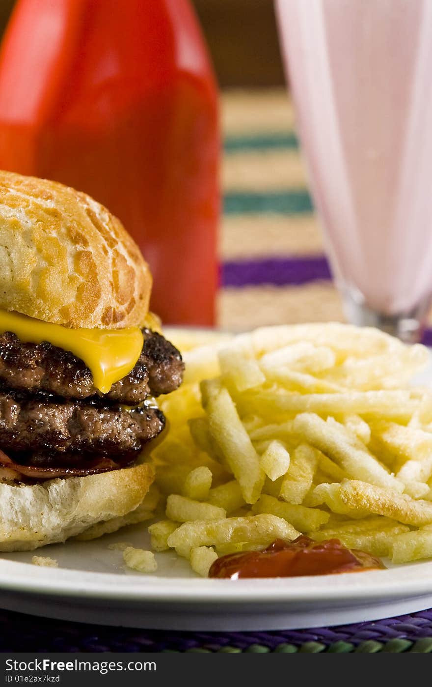 Cheeseburger with fries and strawberry milkshake. Cheeseburger with fries and strawberry milkshake