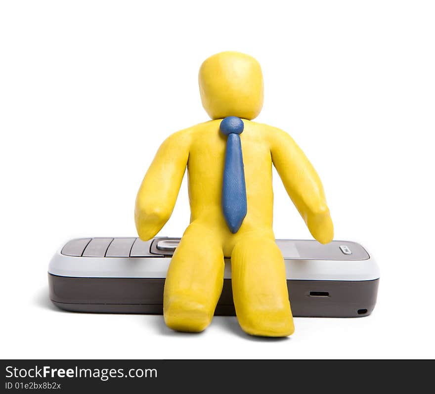 Plasticine manager sitting on mobile phone isolated on white. Plasticine manager sitting on mobile phone isolated on white