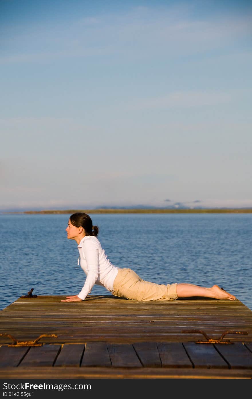 Yoga Woman on a dock by the ocean