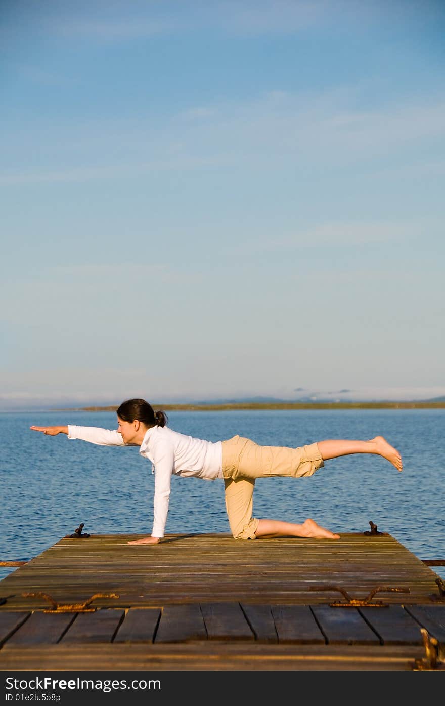 Yoga Woman on a dock by the ocean