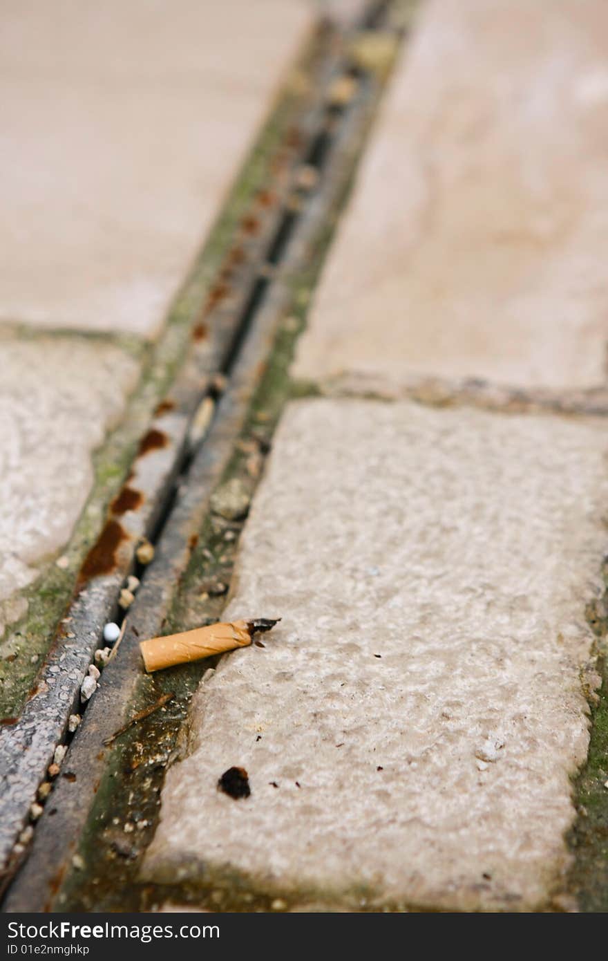 A spent cigarette lying on the ground