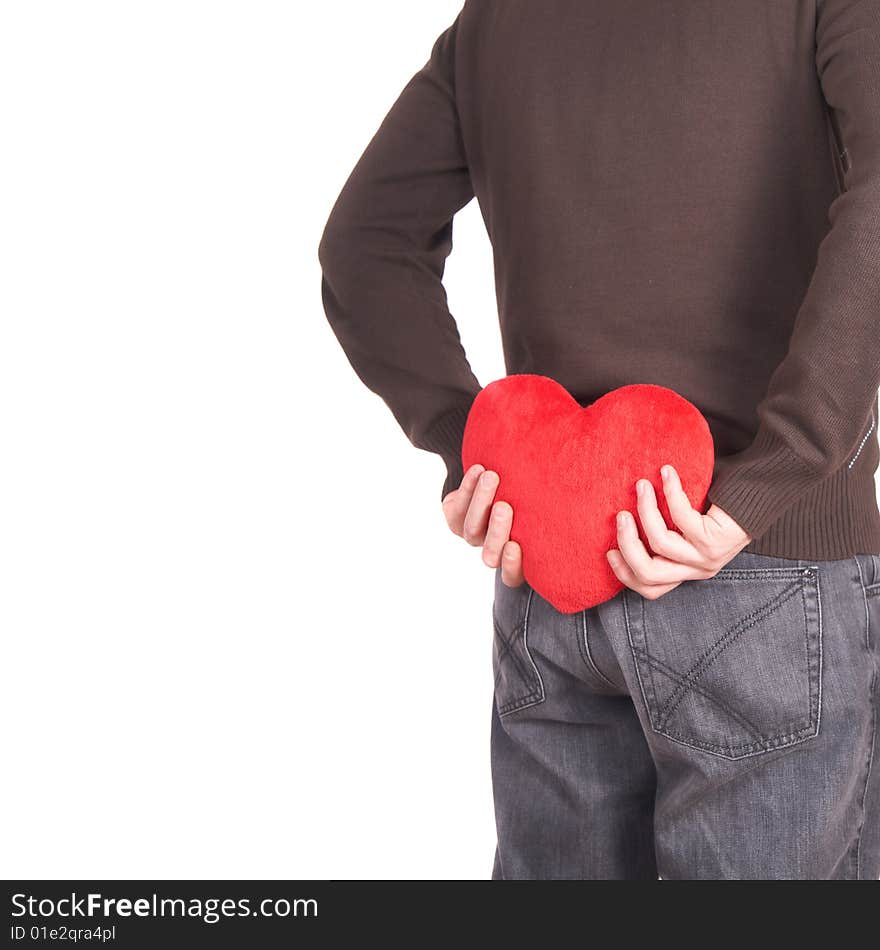 A young man holds a heart shaped pillow behind his back which he gives as a present to his girlfriend for valentines day. Isolated over white. Lot of white copyspace left. A young man holds a heart shaped pillow behind his back which he gives as a present to his girlfriend for valentines day. Isolated over white. Lot of white copyspace left.