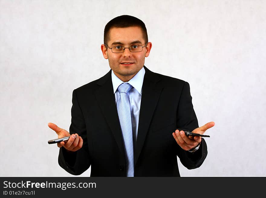 Young businessman on isolated background with a cell phones. Young businessman on isolated background with a cell phones