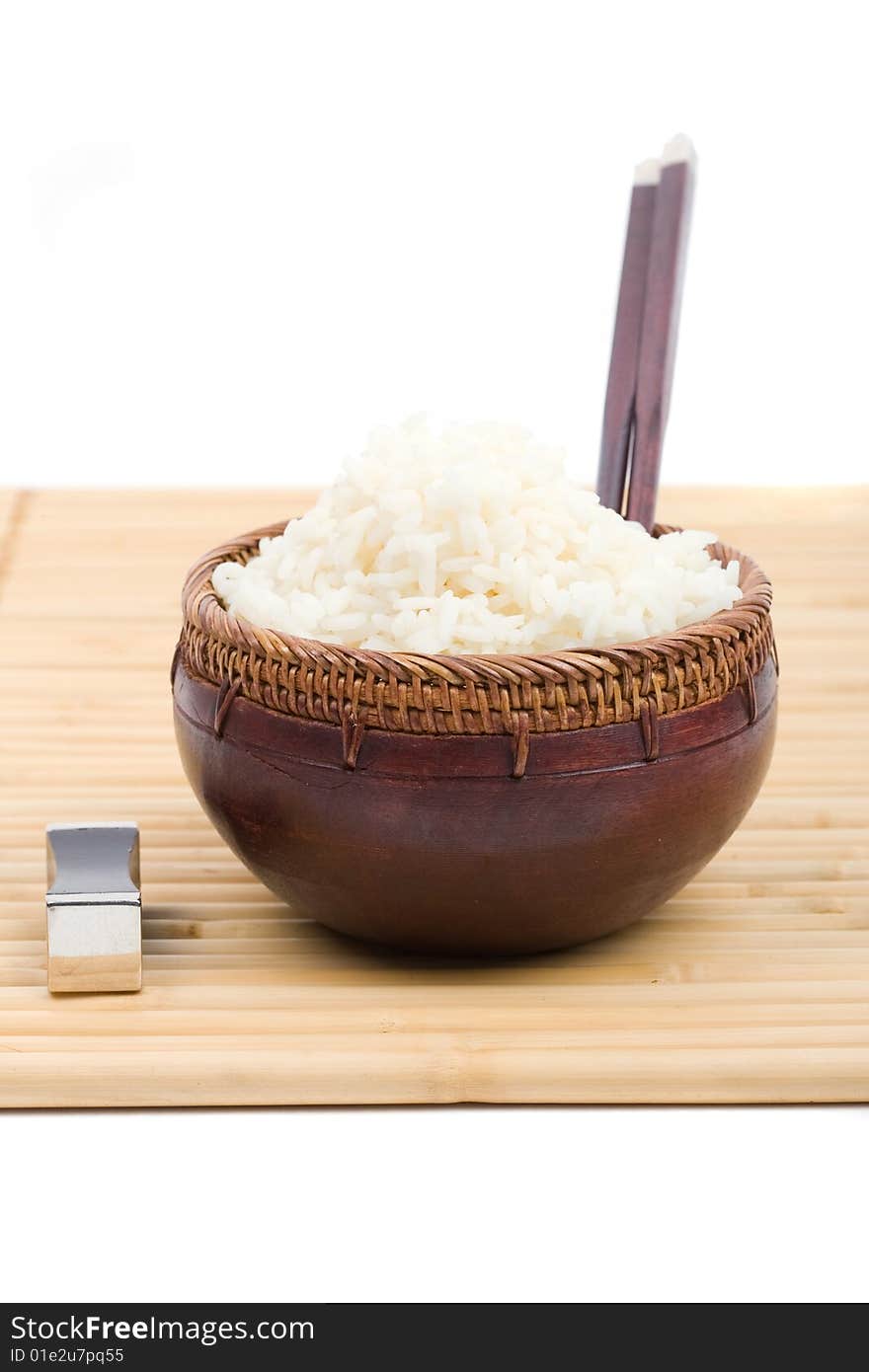 Wood rice bowl and chopsticks on bamboo mat. Wood rice bowl and chopsticks on bamboo mat