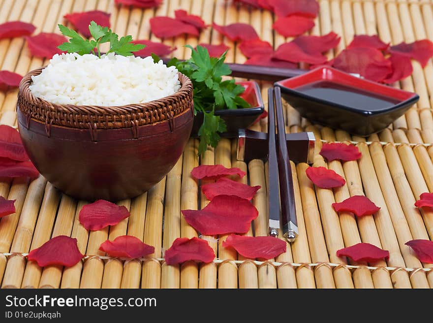 Wood rice bowl and chopsticks on bamboo mat. Wood rice bowl and chopsticks on bamboo mat