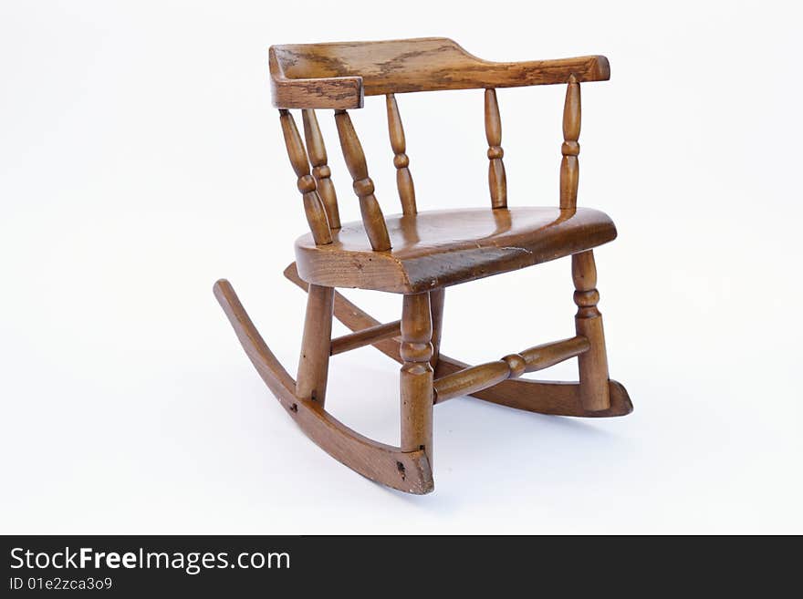 An antique children's rocking chair in finished oak wood. An antique children's rocking chair in finished oak wood