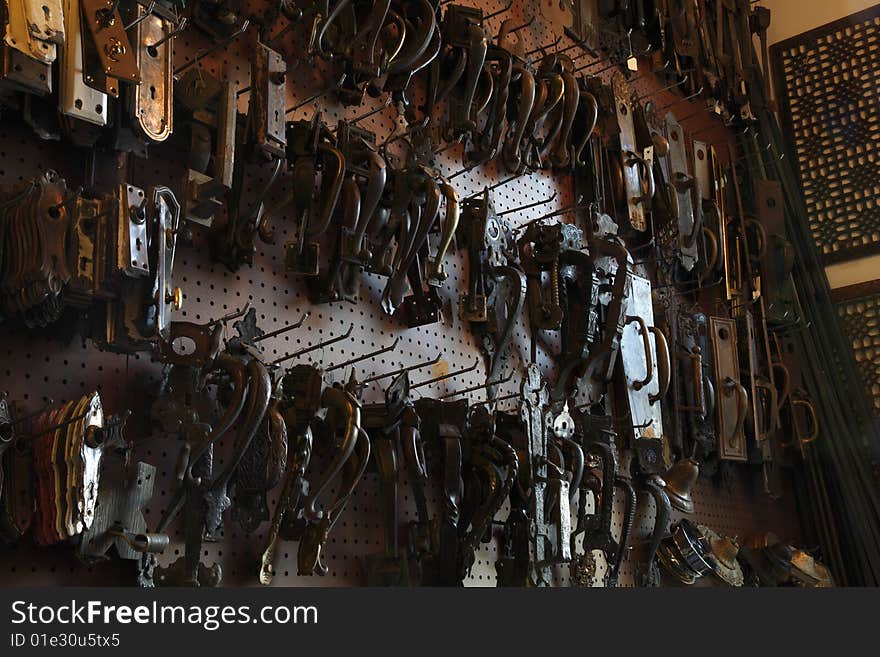 Antique door hardware hanging on a wall in a hardware store