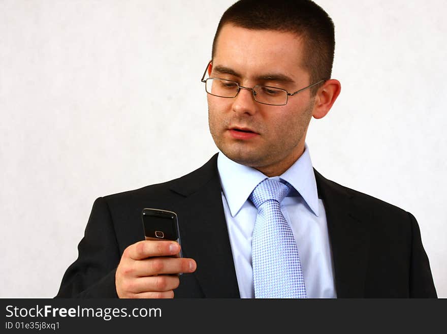 Young businessman on isolated background with his cell phone. Young businessman on isolated background with his cell phone