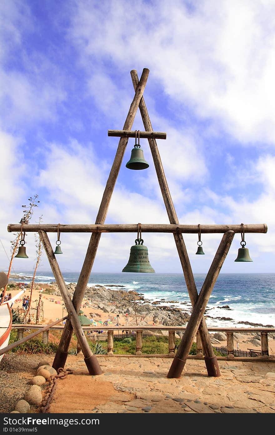 Some bells with the beach on the background.