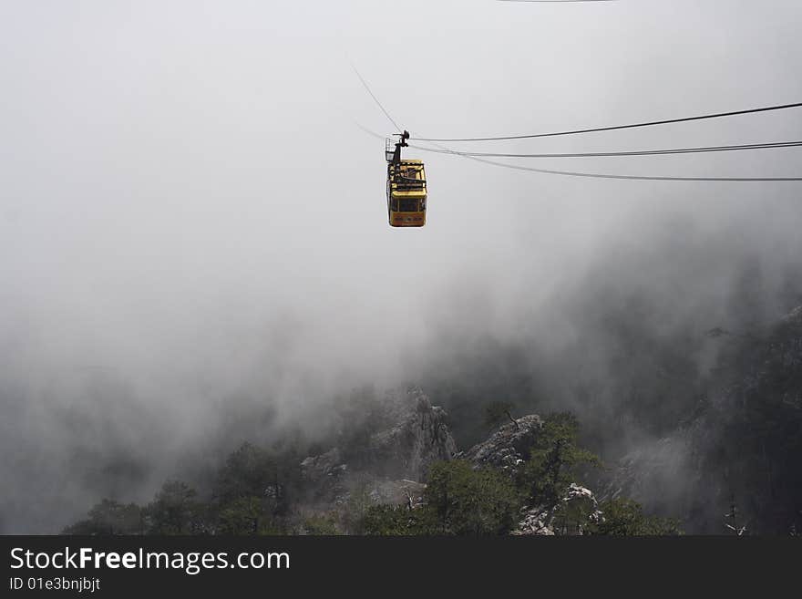 The rope-way car is shown from a cloud. Crimea, Ukraine. The rope-way car is shown from a cloud. Crimea, Ukraine