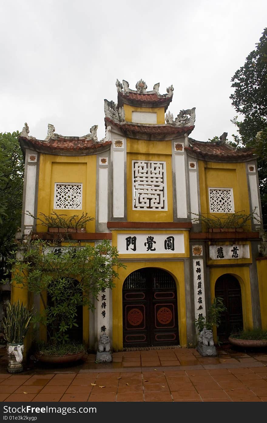 A grand entrance to a Chinese temple in Hanoi.  The temples in Hanoi, use a beautiful mustard yellow color and are usually simply decorated. A grand entrance to a Chinese temple in Hanoi.  The temples in Hanoi, use a beautiful mustard yellow color and are usually simply decorated.