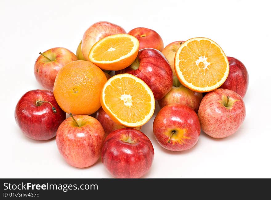 Apples and oranges piled on back background.