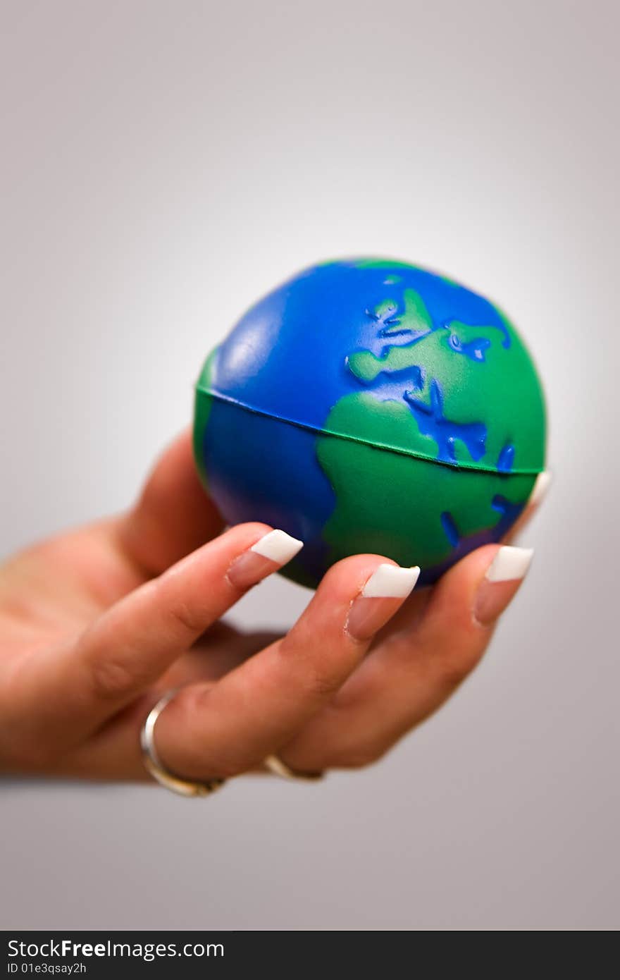 Woman's hand holding toy globe. Woman's hand holding toy globe