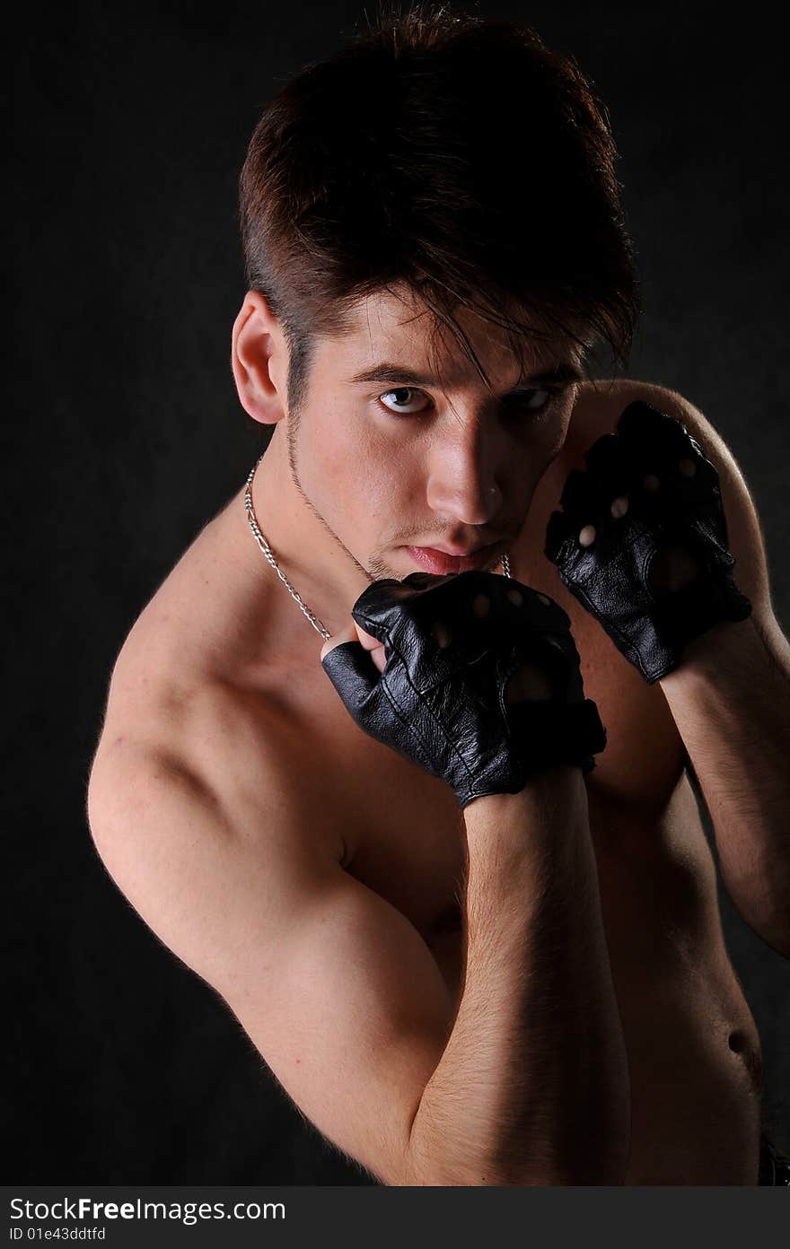 Young man in fighting pose. Studio shot. Black backround. Young man in fighting pose. Studio shot. Black backround.