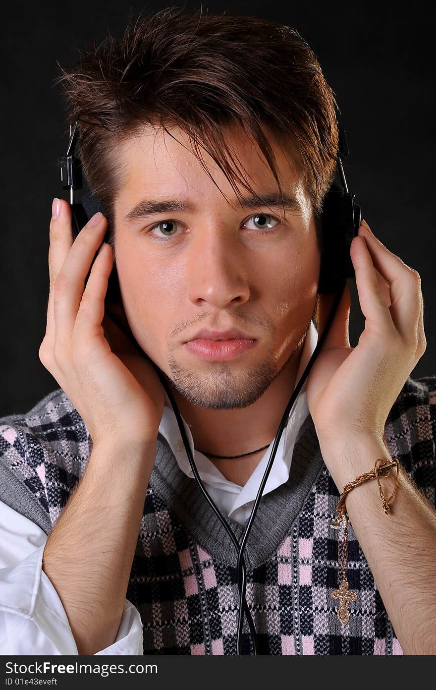 Man listening music in headphones. Black background. Studio shot.