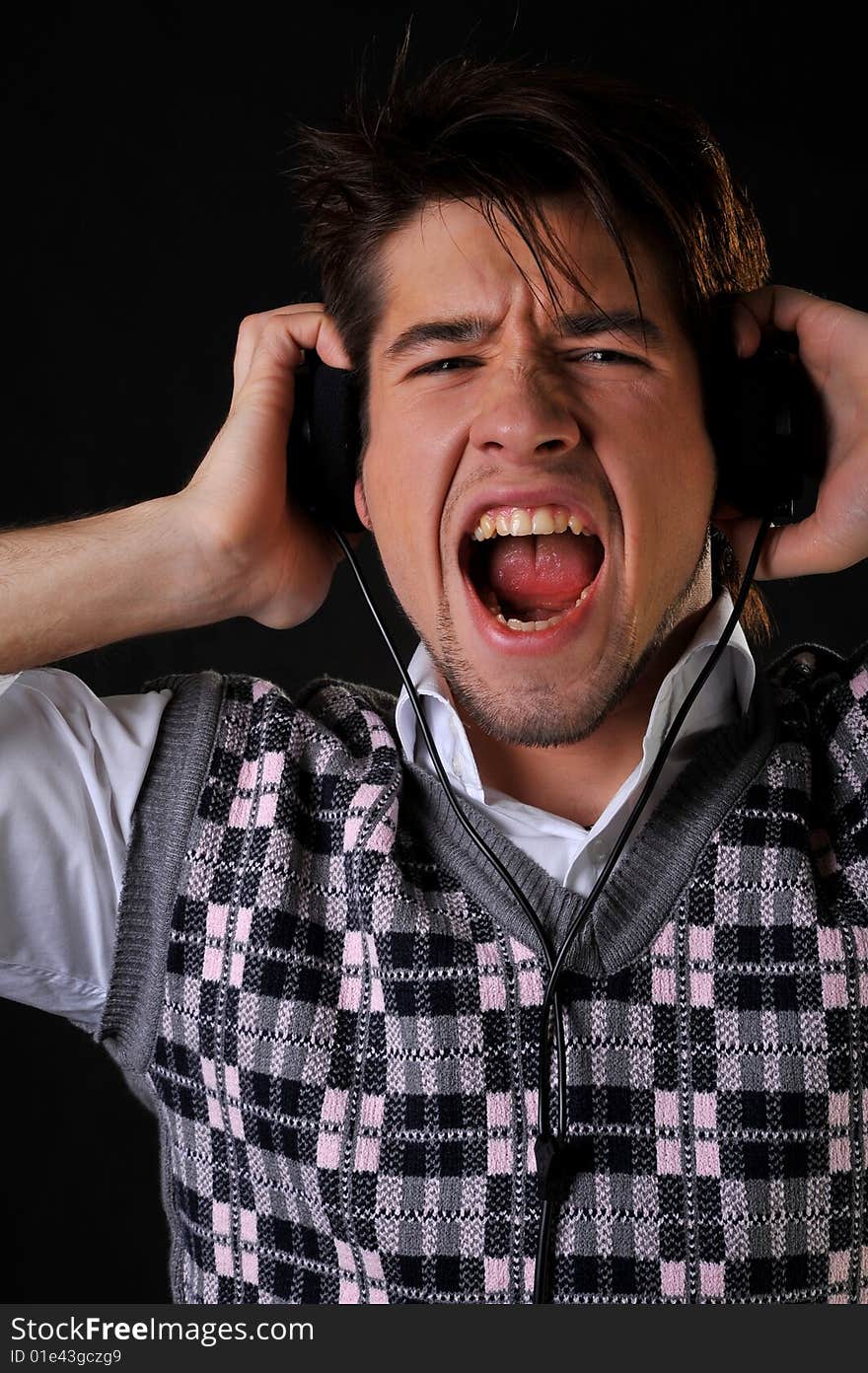 Man listening music in headphones. Black background. Studio shot.