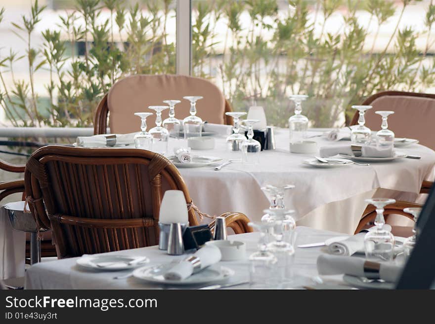 Tables with goblets and napkins inside restaurant