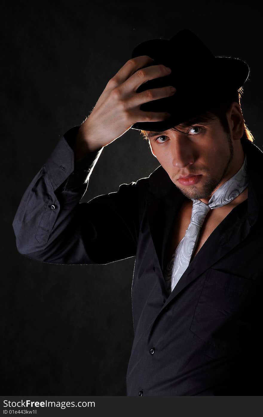 A portrait of a man. Studio shot. Black backround.