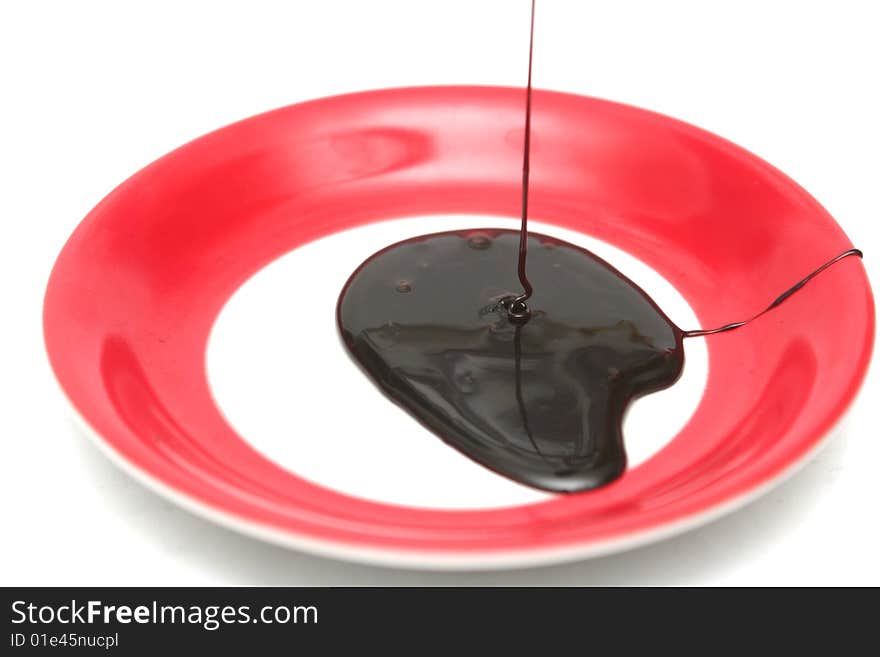 Drops of chocolate on a red plate