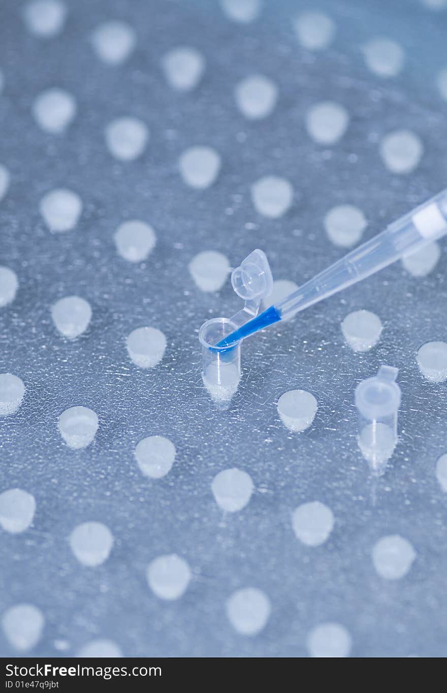 Pipette over test tubes in a science research lab. Pipette over test tubes in a science research lab