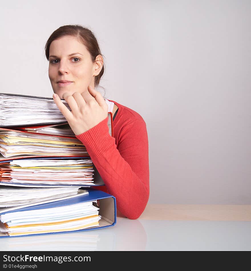 A young woman in front of a stack of paperwork. A lot of copyspace. A young woman in front of a stack of paperwork. A lot of copyspace.