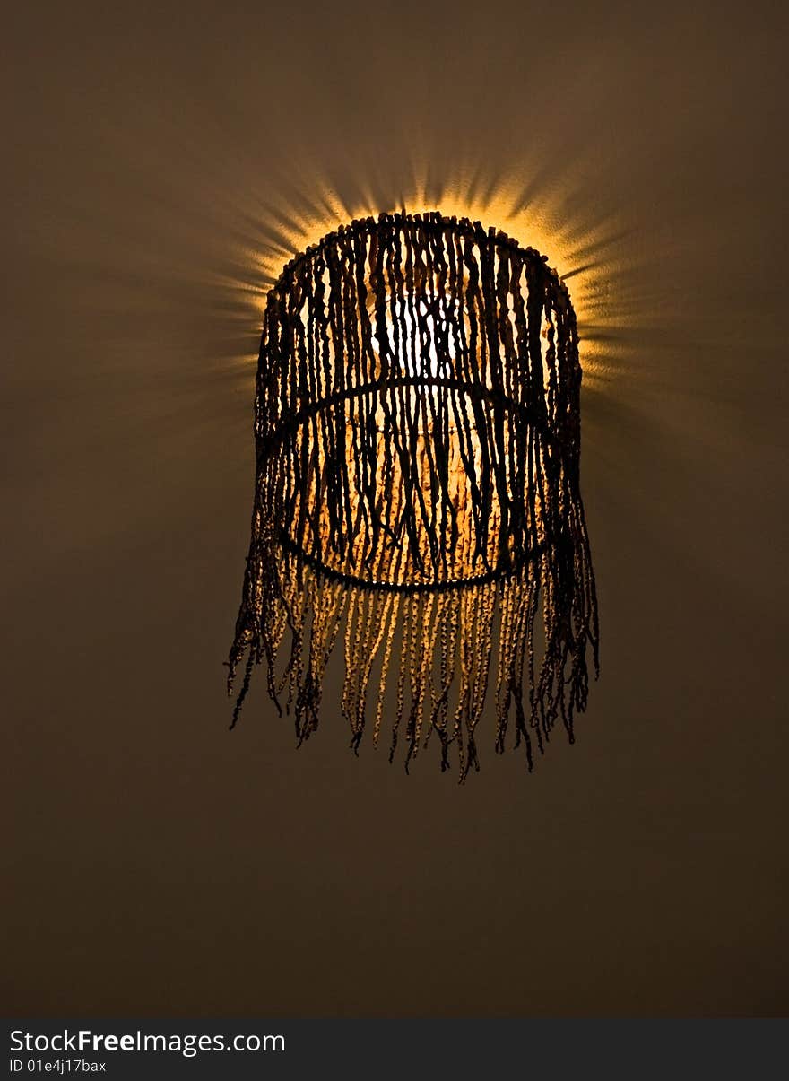 Interesting lampshade woven from twigs with shining light-bulb. Interesting lampshade woven from twigs with shining light-bulb