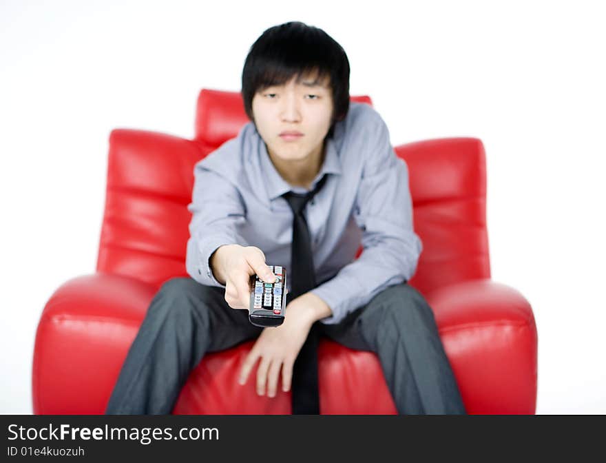 The young man in a grey shirt watches TV