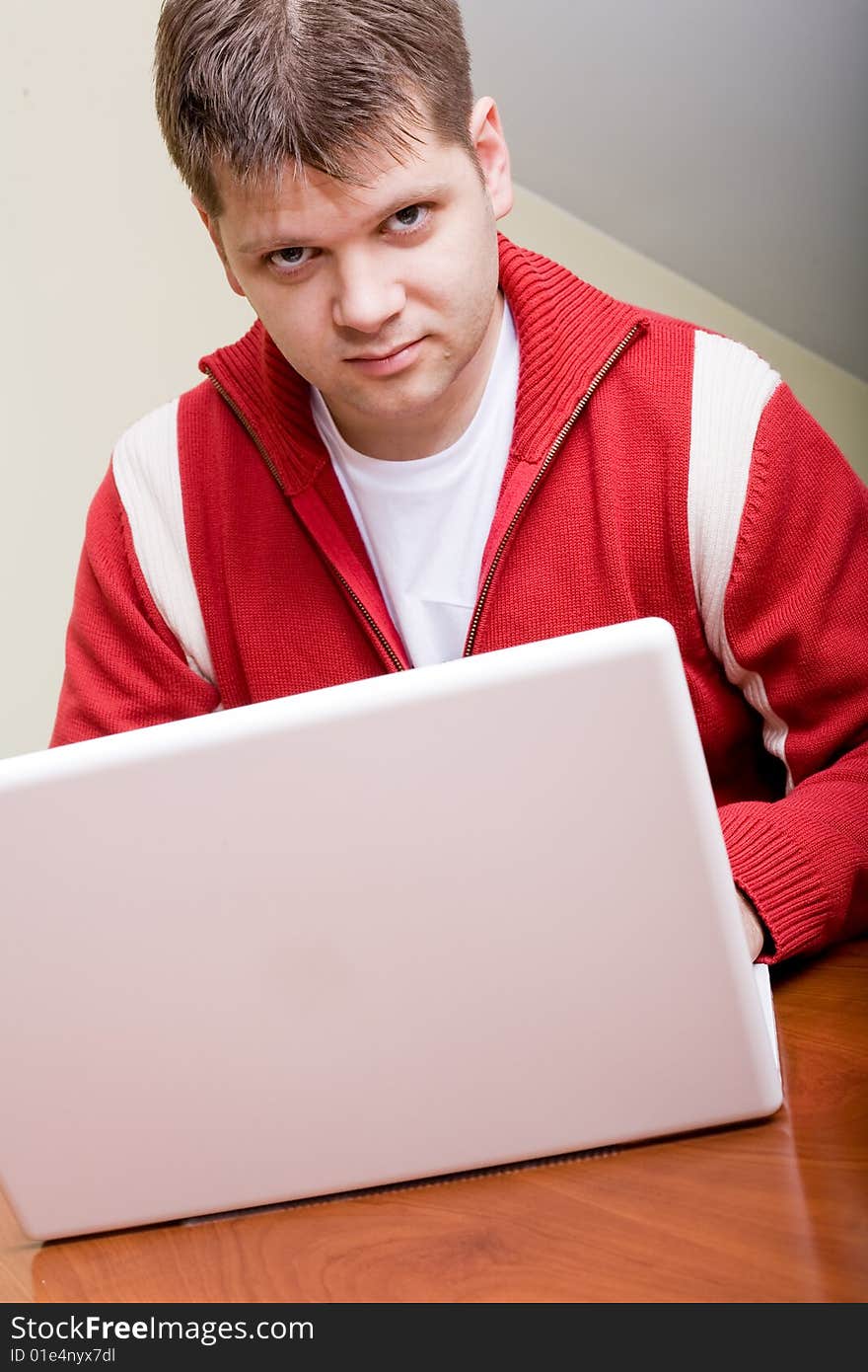 Young man working with a white laptop computer. Young man working with a white laptop computer