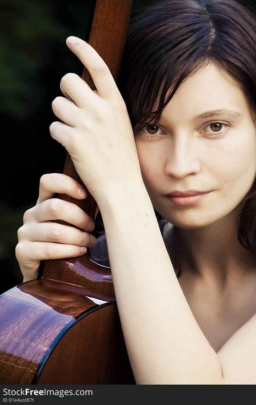 Young pretty woman holding her classic guitar. Young pretty woman holding her classic guitar.