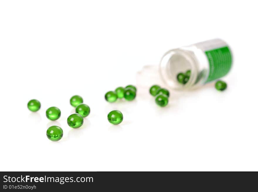 Green gel pills spilled on white surface