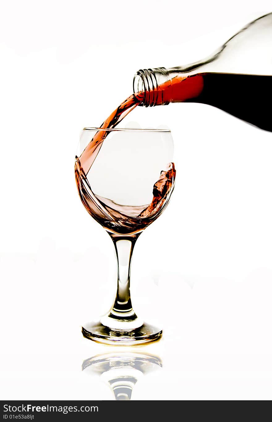 Pouring red wine in glass isolated on white