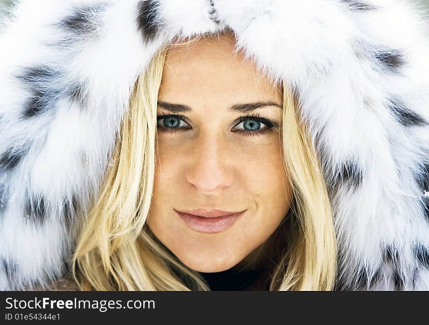 Blond girl wearing white fur coat in winter. Blond girl wearing white fur coat in winter