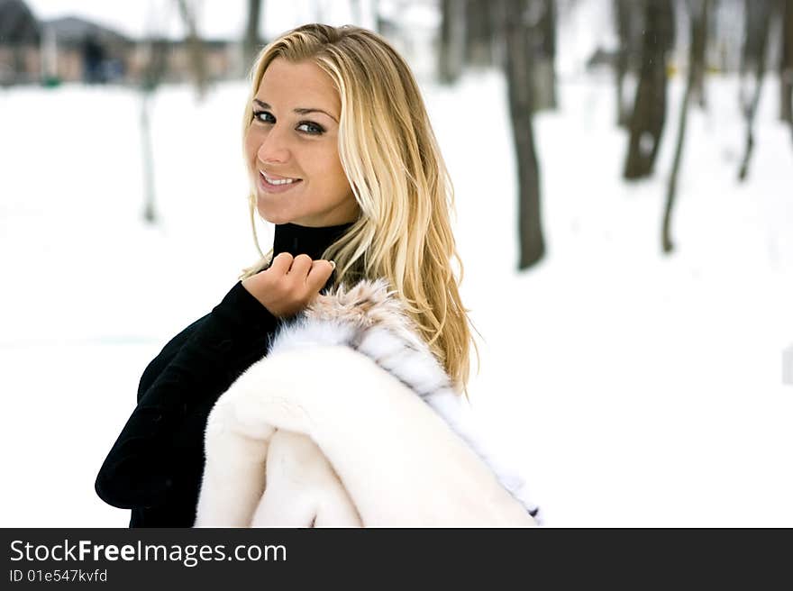 Blond girl wearing white fur coat in winter. Blond girl wearing white fur coat in winter