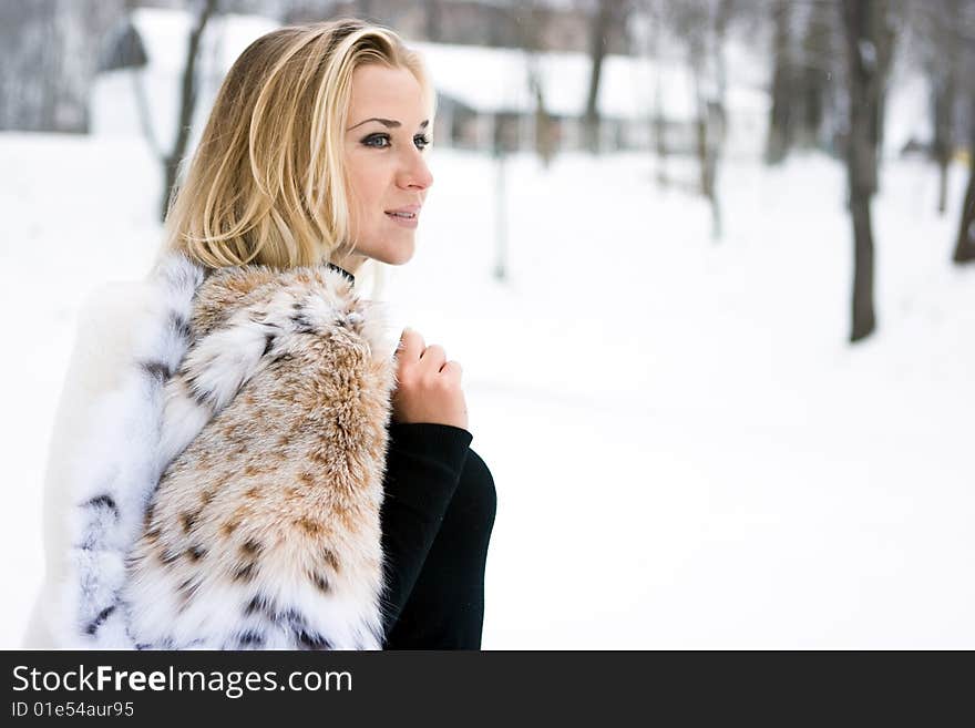 Blond girl wearing white fur coat in winter. Blond girl wearing white fur coat in winter