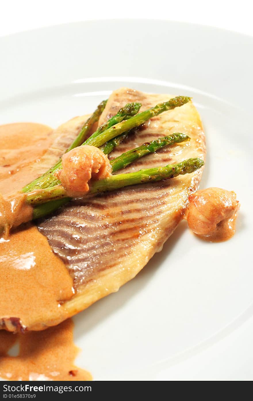 Sea Bass Fillet with Tomato Sauce and Fresh Asparagus. Isolated on White Background