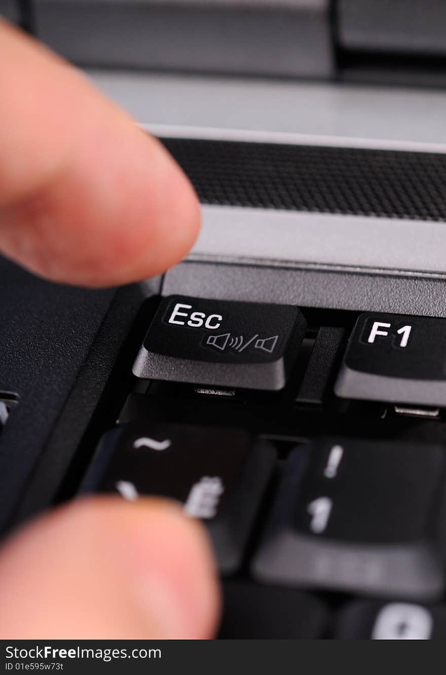 Finger hitting the Escape key