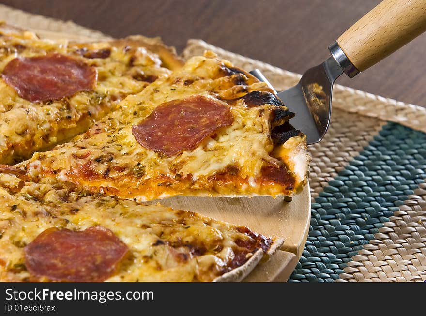 Peperoni pizza served on wooden board