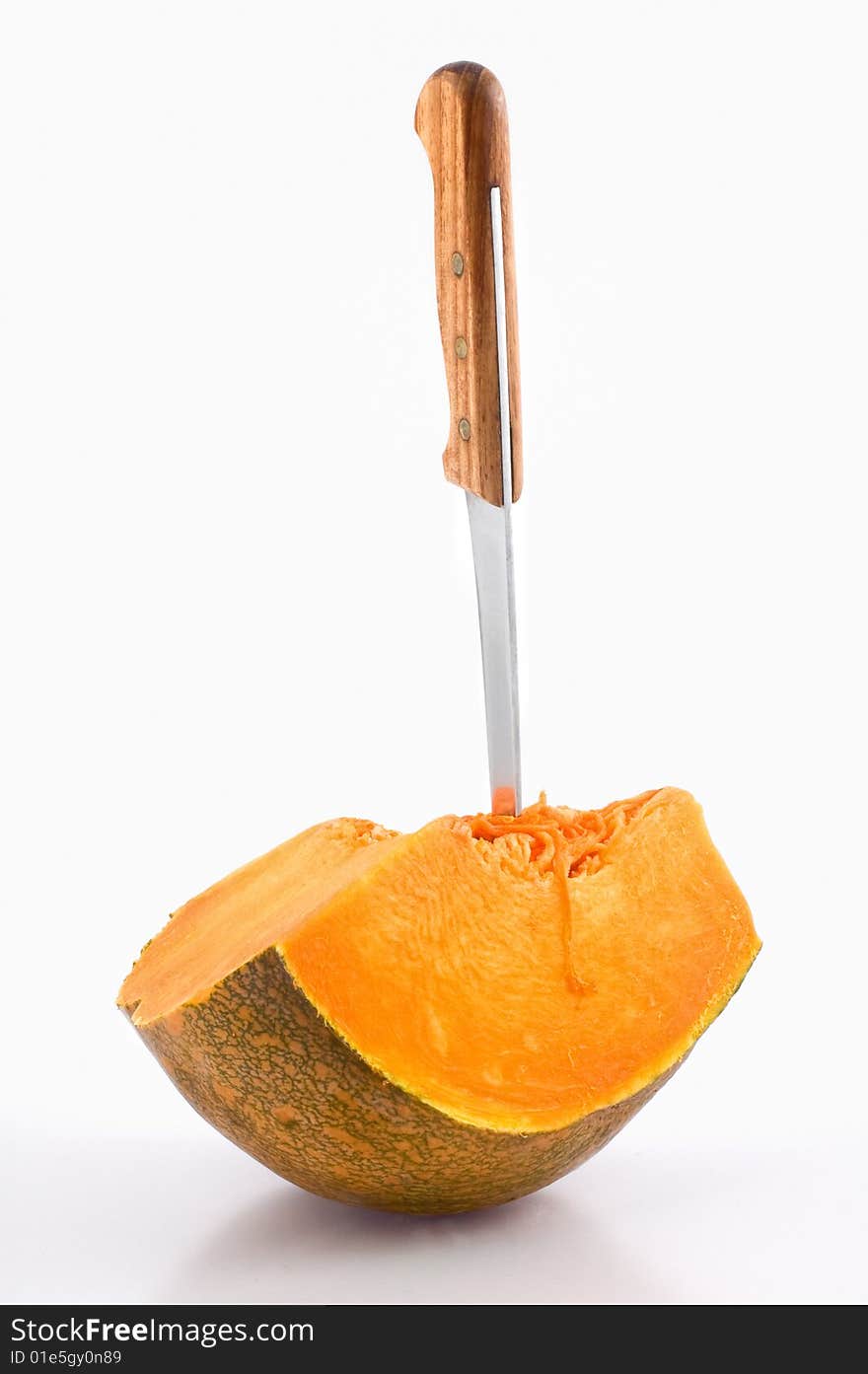 Knife stuck in a slice of pumpkin isolated on white. Knife stuck in a slice of pumpkin isolated on white