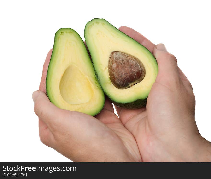 Hands holding halves of ripe acocado