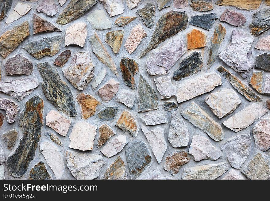 Fragment of rough colored stone wall. Fragment of rough colored stone wall