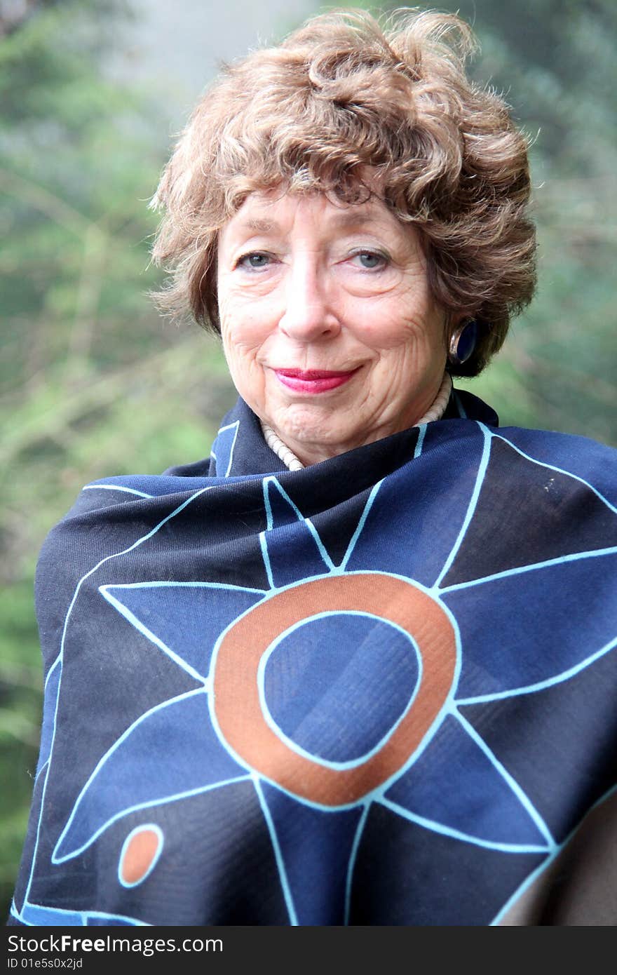 Portrait of a mature female senior standing on her home patio deck.