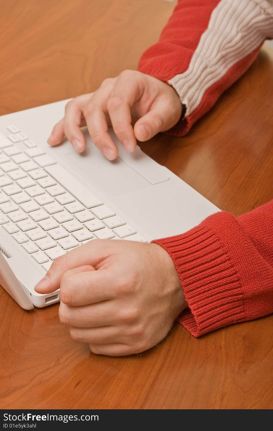 Red pullover and a wood table with laptop and a decision-maker. Red pullover and a wood table with laptop and a decision-maker