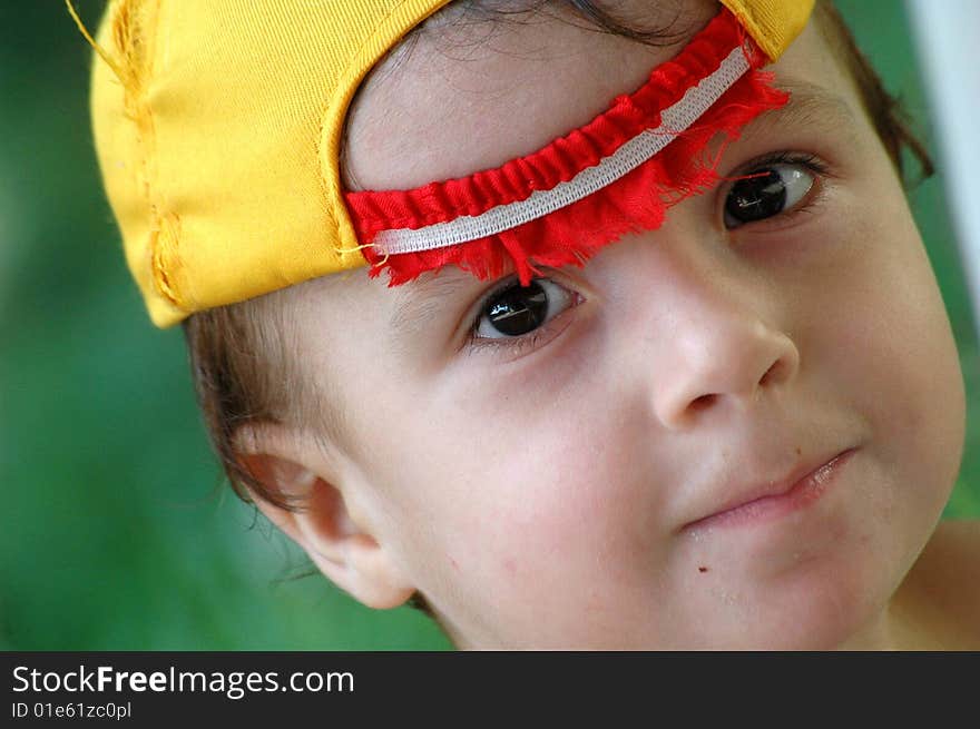 Child of two years with black eyes and yellow cap. Child of two years with black eyes and yellow cap