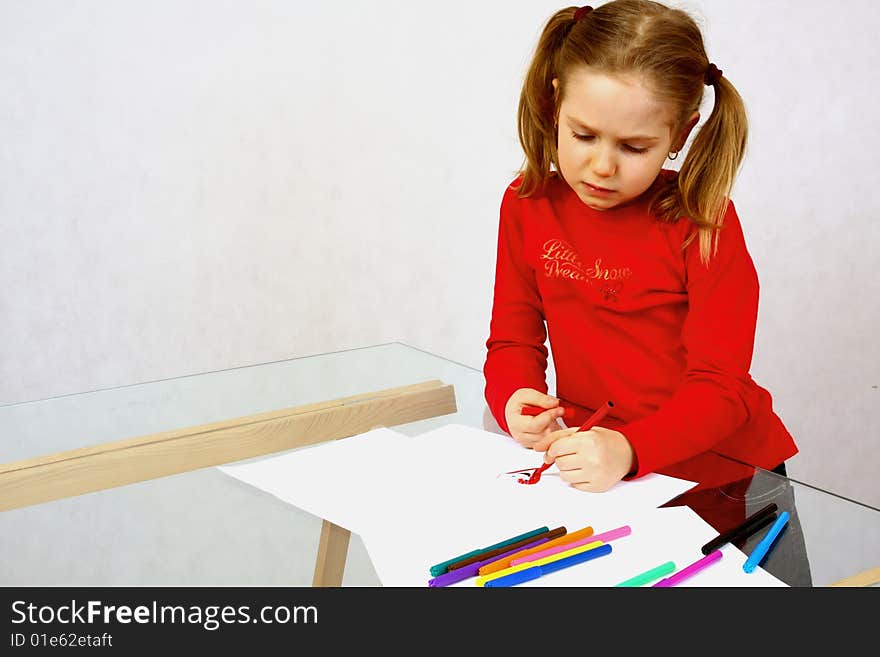 Young girl in red drawing an image. Isolated. Young girl in red drawing an image. Isolated.