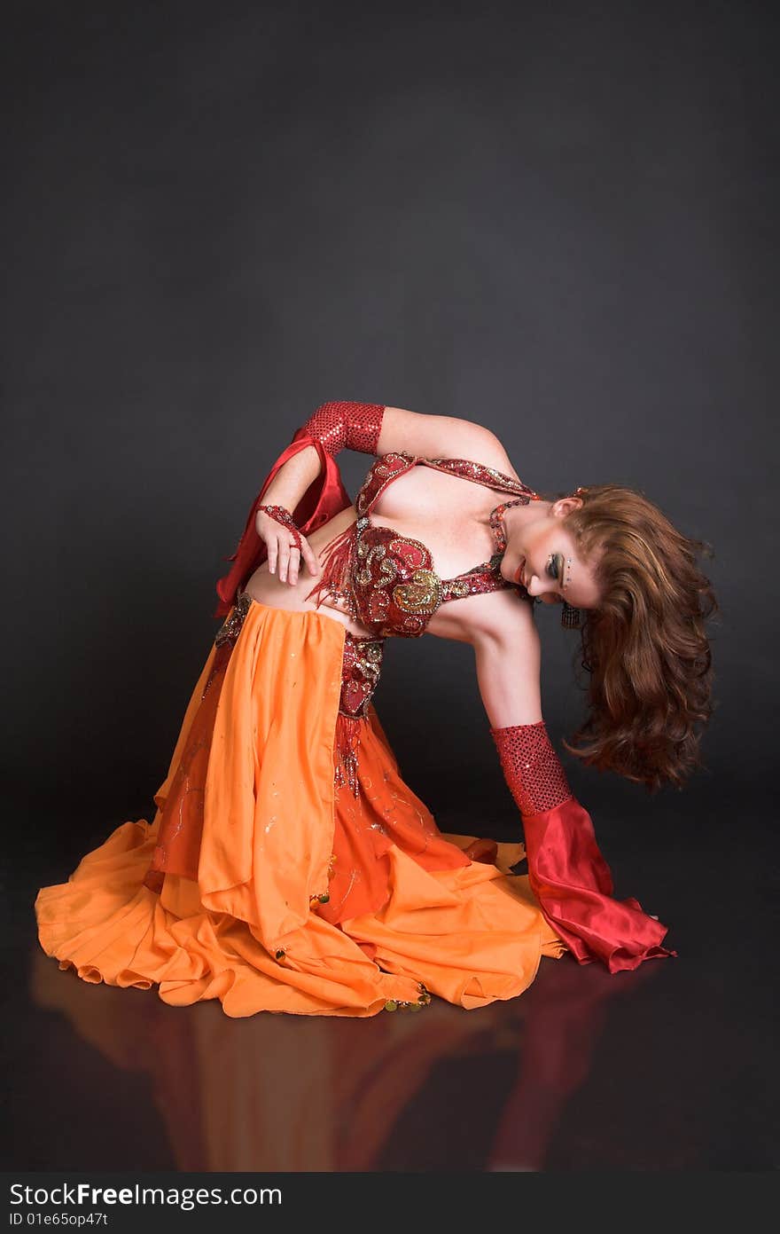 Belly Dancer wearing a red costume with jewelery. Belly Dancer wearing a red costume with jewelery