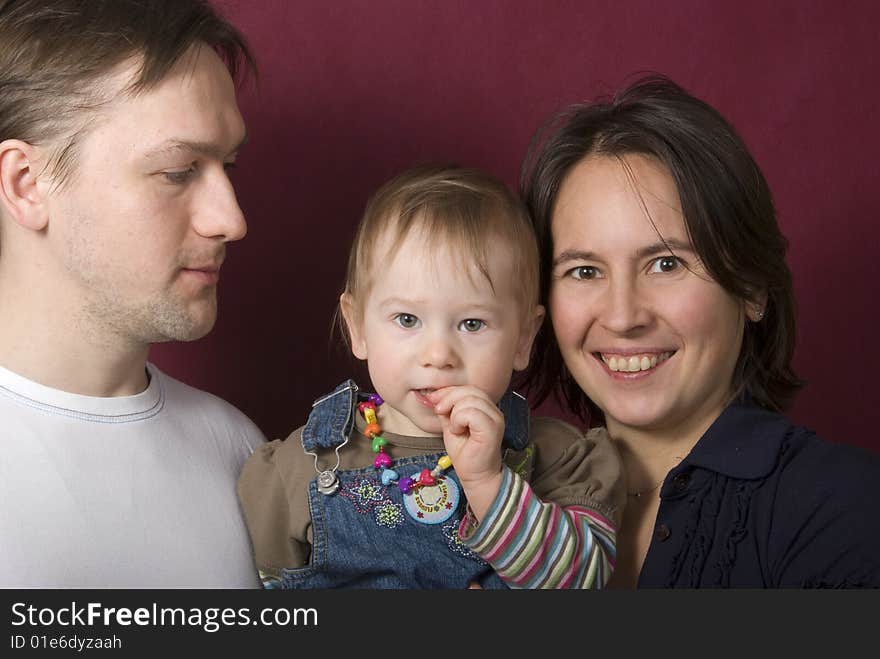 Portrait of father, mather and daughter on the purple background. Portrait of father, mather and daughter on the purple background