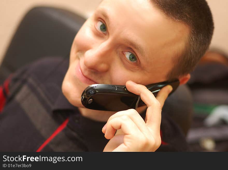 Young man speaks by mobile phone and smiling