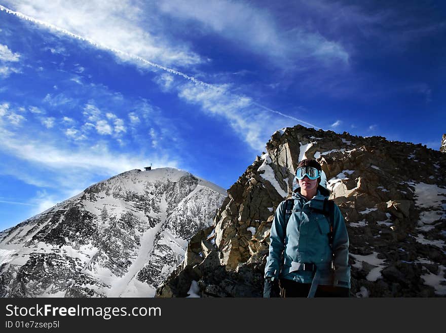 A young, female snowboarder on a treacherous hike below Lone Peak at Big Sky Resort. A young, female snowboarder on a treacherous hike below Lone Peak at Big Sky Resort.