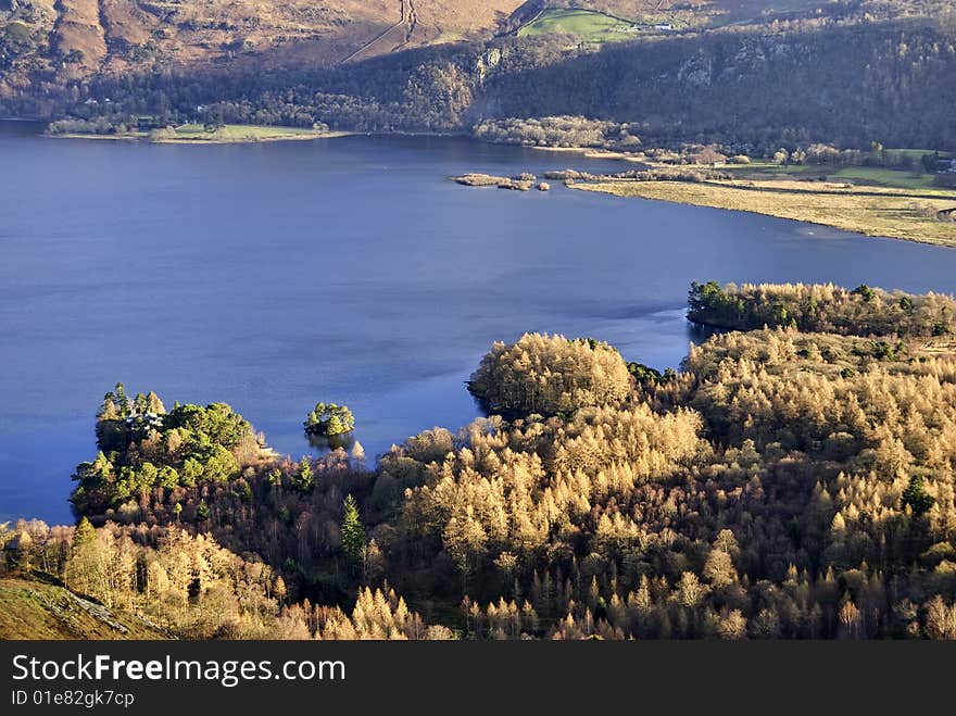 Aerial view across the Southern end of Derwent Water in the English Lake District with coniferous forest on the shore